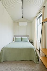 ein Schlafzimmer mit einem grünen Bett in einem Zimmer mit Fenstern in der Unterkunft Jolly Knight Motel 