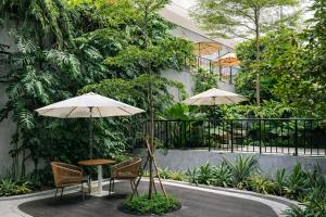 a table and chairs with umbrellas in a courtyard at Rose & Golf at Rose Apple Square in Siem Reap