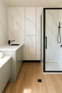 ein Bad mit einer Dusche und weißen Schränken in der Unterkunft Jolly Knight Motel 