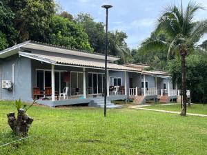 ein blaues Haus mit einer Palme im Hof in der Unterkunft Ban Supattra in Ban Khlong Mat