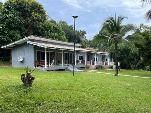 a house in a yard with a fire hydrant in the grass at Ban Supattra in Ban Khlong Mat