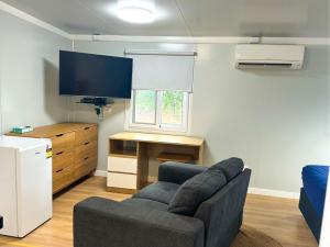 a living room with a couch and a flat screen tv at Breeze Holiday Parks - Mary River in Marrakai
