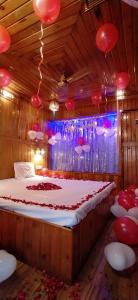 ein Schlafzimmer mit einem großen Bett mit roten Ballons an der Decke in der Unterkunft ALTAF's MOTEL in Matheran