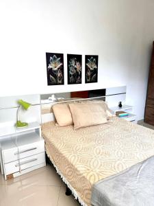 维多利亚-达孔基斯塔Aconchego Smart - Perto de tudo!的一间带床和床头柜的白色卧室