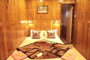 Bett in einem Zimmer mit Holzwänden in der Unterkunft ALTAF's MOTEL in Matheran