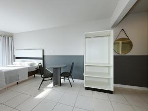 a bedroom with a bed and a table and chairs at Smart Stay Lofts in Joinville