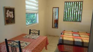 een slaapkamer met twee bedden en een raam bij La Casita in Gamboa