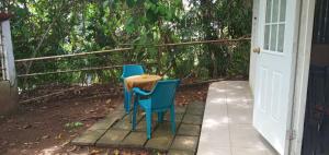 twee blauwe stoelen en een tafel op een veranda bij La Casita in Gamboa +5 foto's