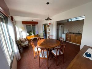 una cucina e una sala da pranzo con tavolo e sedie in legno di Casa de Alvita a Villa Carlos Paz Altre 6 foto