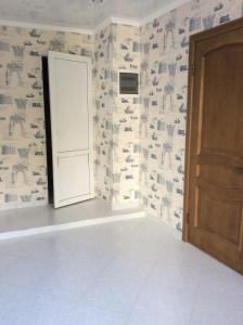 um quarto com uma porta e uma parede coberta de papel de parede em Guest House na Komarov 1 em Gagra
