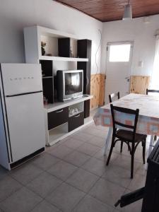 un soggiorno con tavolo e frigorifero bianco di La casita a Pringles