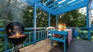 a bbq on a deck with a table and a grill at Ganghwa Picnic Pension in Incheon