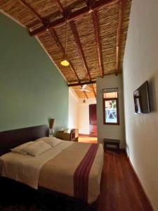 a bedroom with a large bed with a wooden ceiling at ViaVia Ayacucho in Ayacucho