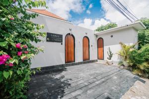 a white house with wooden doors and a courtyard at Modern 1BR Loft style with pool in Pegending in Dalung