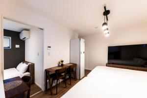 ein Hotelzimmer mit Bett und Schreibtisch in der Unterkunft AYA HOTELS 博多 1st in Fukuoka