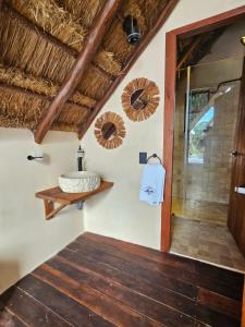 een badkamer met een douche en een houten vloer bij Kaaj Ndomi in Bacalar