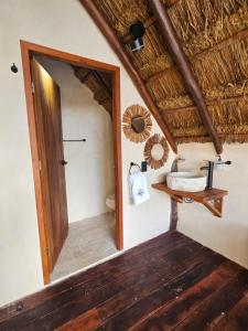 ein Badezimmer mit Spiegel und Toilette unter einem Strohdach in der Unterkunft Kaaj Ndomi in Bacalar + 44 Fotos