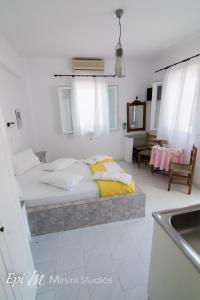 1 dormitorio con cama y lavamanos en Mirsini Studios, en Parasporos