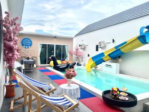 a house with a pool and a water slide at Sea Fan Cha-am Pool Villa in Ban Bo Prakhon
