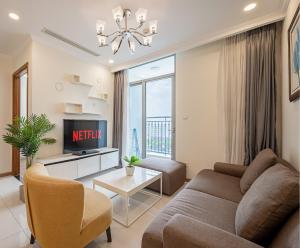 a living room with a couch and a tv at Luminous Landmark Apartment in Ho Chi Minh City