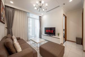a living room with a couch and a tv at Luminous Landmark Apartment in Ho Chi Minh City