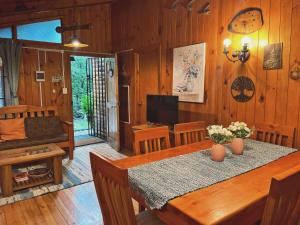 a dining room with a table and a television at Refugio araucano - Lican Ray in Licán Ray