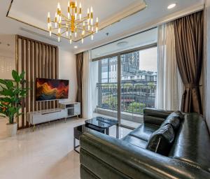 a living room with a leather couch and a large window at Luminous Landmark Apartment in Ho Chi Minh City
