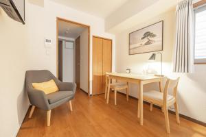 a room with a desk and a chair and a table at Dash Living Shinjuku in Tokyo