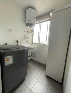 a small kitchen with a sink and a refrigerator at Acogedora habitación in Lima +1 photo