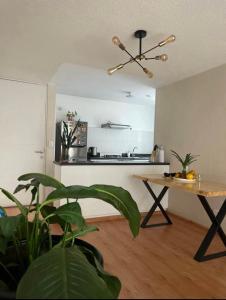 a living room with a table and a kitchen at Acogedora habitación in Lima