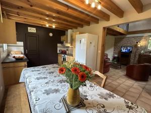 a vase of flowers sitting on a table in a kitchen at Gite de lescurade in Escource