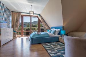um quarto com uma cama e uma grande janela em Apartamenty Oaza Deluxe Zakopane em Zakopane