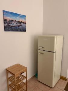 a white refrigerator in a room with a picture on the wall at Ferienwohnung am Senftenberger See - Wohnung 2 in Senftenberg +9 photos