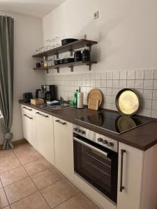 une cuisine avec une cuisinière et un évier dans l'établissement Apartment nahe Senftenberger See - Wohnung 2, à Senftenberg 7 autres photos