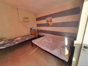 two beds in a room with stripes on the wall at Kantil Dive Resort in Batangas City
