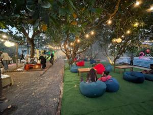 Eine Gruppe von Menschen, die auf Bohnensäcken auf dem Gras sitzen in der Unterkunft 12 Monks - Backpacker Resort in Arambol + 29 Fotos