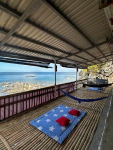a hammock on a deck with a view of the ocean at Kantil Dive Resort in Batangas City