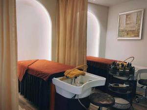 a bathroom with a sink in front of a table at Maccal Boutique Hotel Dalat in Da Lat +16 photos