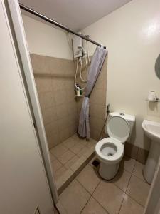 een kleine badkamer met toilet en douche bij Stanford Suites 1 in Silang
