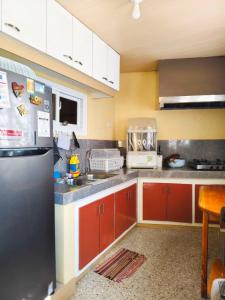 a kitchen with red cabinets and a stainless steel refrigerator at Baguio Staycation with Mountain View in La Trinidad