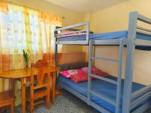 a room with two bunk beds and a table at Baguio Staycation with Mountain View in La Trinidad