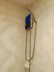 a shower in a bathroom with a shower head at Baguio Staycation with Mountain View in La Trinidad