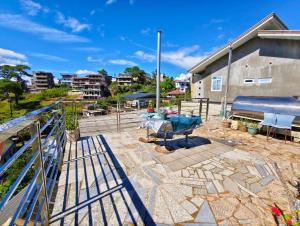 a patio with a table and chairs and a building at Baguio Staycation with Mountain View in La Trinidad