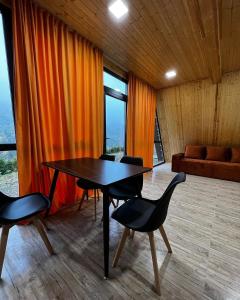 a dining room with a table and chairs and a couch at Green Villa Resort Orange in Dilijan