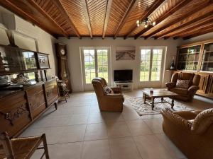 een grote woonkamer met stoelen en een televisie bij Le gite grues cendrees in Arjuzanx