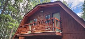 a large wooden cabin with a balcony in the woods at Brown Family Farm in Grand Forks