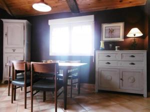 una sala da pranzo con tavolo, sedie e una finestra di Le coursin a Saubrigues