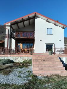 ein Haus mit einem Balkon und einer Treppe davor in der Unterkunft Private secluded villa for 20 guests on large private estate - Cairo Montenotte - Tenniscourt - Savone in Cairo Montenotte