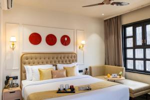 ein Schlafzimmer mit einem großen Bett und roten Tellern an der Wand in der Unterkunft The Naori by Alaya Stays in Udaipur