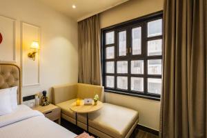 ein Hotelzimmer mit einem Bett, einem Tisch und einem Fenster in der Unterkunft The Naori by Alaya Stays in Udaipur